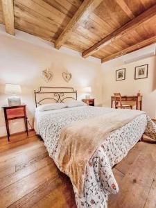sypialnia z dużym łóżkiem i drewnianym sufitem w obiekcie Da Titta w mieście Pitigliano