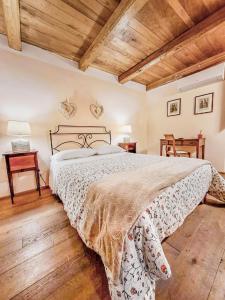 a bedroom with a large bed and wooden ceilings at Da Titta in Pitigliano