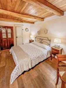 a bedroom with a large bed and a wooden ceiling at Da Titta in Pitigliano