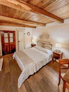 sypialnia z łóżkiem i drewnianym sufitem w obiekcie Da Titta w mieście Pitigliano