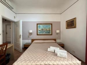 a bedroom with a bed with two towels on it at Althea Rooms in Florence