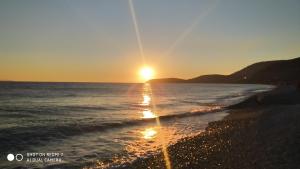 a sunset on a beach with the ocean at Hotel Villa Ruci in Ksamil
