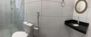 uma casa de banho branca com um WC e um espelho. em POUSADA E AGENCIA CLEDIO TURISMO em Barreirinhas