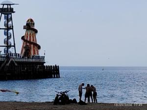 a group of people standing on the beach near the ocean at Blue Palms in Bournemouth