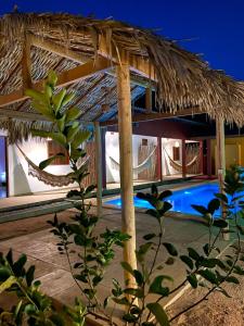 um resort com um telhado de palha e uma piscina em Casa da Lagoa em Jijoca de Jericoacoara