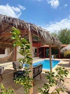 a resort with a swimming pool and a straw hut at Casa da Lagoa in Jijoca de Jericoacoara