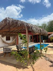 Cabaña con 2 bancos junto a una piscina en Casa da Lagoa, en Jijoca de Jericoacoara