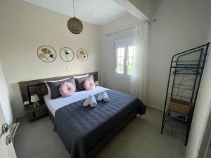 a bedroom with a bed with two pink pillows at Armonia Guest House in Nea Roda