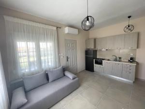 a living room with a couch and a kitchen at Armonia Guest House in Nea Roda