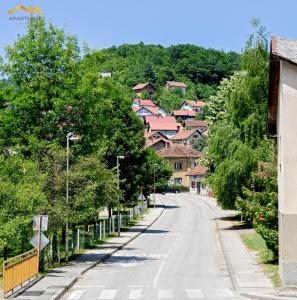 a street in a village with trees and houses at Apartmani Jaguzovic in Mrkonjić Grad