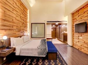 a hotel room with a bed and a tv at Hotel Seven Villa Near Delhi Airport in New Delhi