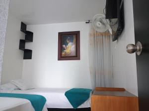 1 dormitorio con 2 camas y una foto en la pared en construcciones Guaduales del café, en Montenegro