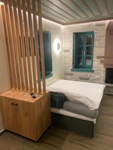 a small bedroom with a bed and a wooden cabinet at MAKRIS Papigo Luxury suites in Papigko