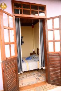 1 dormitorio con puerta abierta y cama en Pousada Residência Balestra, en Tiradentes
