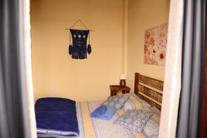 um quarto com uma cama com lençóis e almofadas azuis em Pousada Residência Balestra em Tiradentes