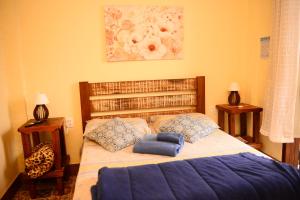 a bedroom with a large bed with blue pillows at Pousada Residência Balestra in Tiradentes