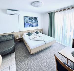 a bedroom with a bed and a table and a couch at Villa Osipovica in Medulin