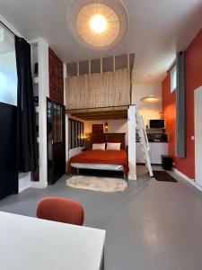 a bedroom with a bunk bed and a red wall at ORANGE Studio in Bois-Colombes