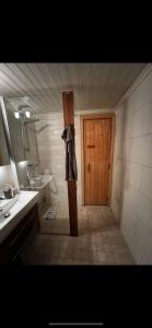 een badkamer met een wastafel en een houten deur bij Badstue, 3 soverom, nytt bad og kjøkken i Åre in Åre
