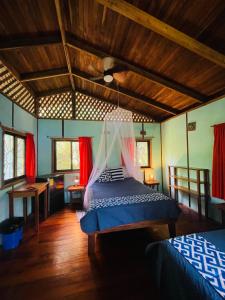 a bedroom with a bed with a mosquito net at Cabinas Yamann in Manzanillo