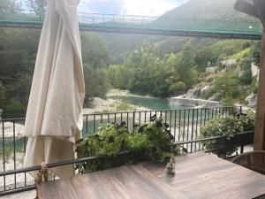 a balcony with a table with a view of a river at Chambre campagnarde in Roquestéron