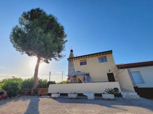 a house with a tree and a white fence at Casa Verna Jacuzzi y Barbacoa in Murcia