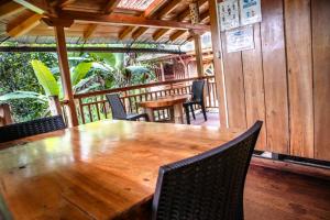 a wooden table and chairs in a restaurant at La Casa de Cecilia Mindo in Mindo