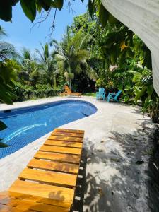einen Pool mit einem Holzweg, der zu einem Resort führt in der Unterkunft Cabinas Yamann in Manzanillo