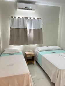 2 camas en una habitación con ventana en POUSADA E AGENCIA CLEDIO TURISMO, en Barreirinhas