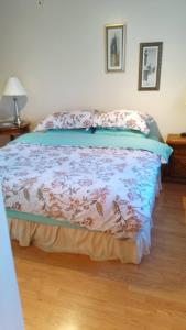 1 dormitorio con 1 cama con colcha de flores en Home Away from Home - Guest Suite 1 en Red Deer