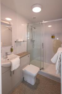 y baño con ducha, aseo y lavamanos. en Manor Hotel en Exmouth