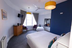 Manor Hotel في اكسماوث: غرفة نوم بسرير وجدار ازرق
