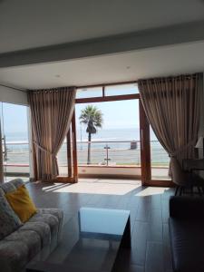 a living room with a couch and a view of the ocean at Hermosos Dptos Sunset Point Huanchaco in Huanchaco