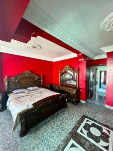 - une chambre avec des murs rouges et un grand lit dans l'établissement M'a Raffiné appartement 2, à Casablanca