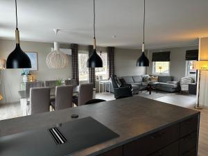 a kitchen and living room with black pendant lights at Senja Peak Panorama in Straumstad
