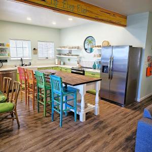 Una cocina con mesa y sillas y un refrigerador. en Aly-Kats Flip Flop Flat, en Rockport
