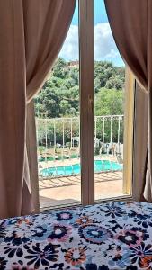 1 dormitorio con vistas a la piscina a través de una ventana en Villa Agnese, en Badesi