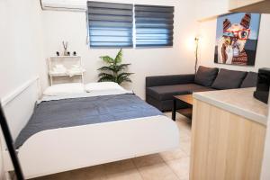 a living room with a bed and a couch at BK Apartment Semi-Basement in Néa Khilí