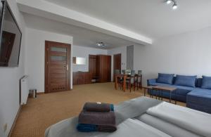 1 dormitorio con sofá azul y sala de estar en Willa MAJA, en Krynica-Zdrój