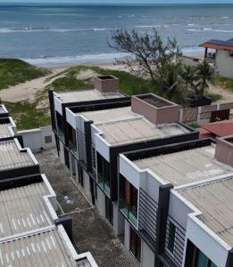 uma linha de edifícios com a praia ao fundo em Casa Amar Cumbuco em Cumbuco