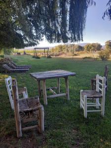 a picnic table and two chairs with a table and a playground at Posta Kamak Eco Posada Rural in Bella Vista