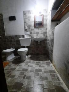 uma casa de banho com um WC, um bidé e um lavatório. em Posta Kamak Eco Posada Rural em Bella Vista