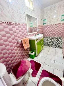 une salle de bains rose avec toilettes et lavabo. dans l'établissement M'a Raffiné appartement 2, à Casablanca
