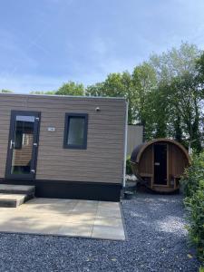 une petite maison avec une grande porte et un bâtiment dans l'établissement Kindvriendelijk luxe chalet in de bossen met privé sauna, à Harderwijk