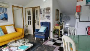 a living room with a yellow couch and a table at ATTIC BAY - Cozy Stay with Sea View in Câmara de Lobos