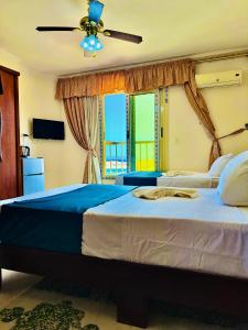 bianco Hotel & Suites في مرسى مطروح: غرفة نوم بسرير كبير مع مروحة سقف