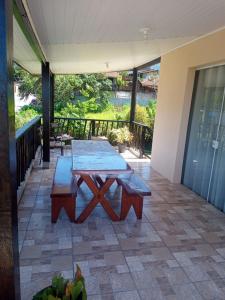 patio con mesa de picnic en el balcón en The House, en Ilhabela