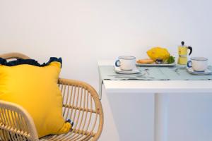a table with a yellow pillow and a plate of food at o' mar - Amalfi Coast Suite in Praiano