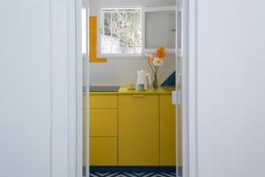 a kitchen with yellow cabinets and a window at o' mar - Amalfi Coast Suite in Praiano