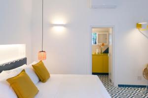 a bedroom with a white bed with yellow pillows at o' mar - Amalfi Coast Suite in Praiano